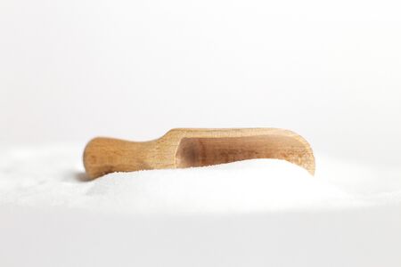 Salt grain in wooden spoon top view on a white background , flat lay.の写真素材