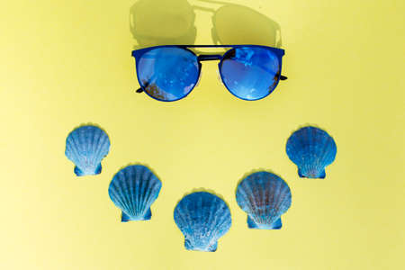 Travel vacation background. Sun glasses sea shells yellow background. Concept summer holidays.の写真素材