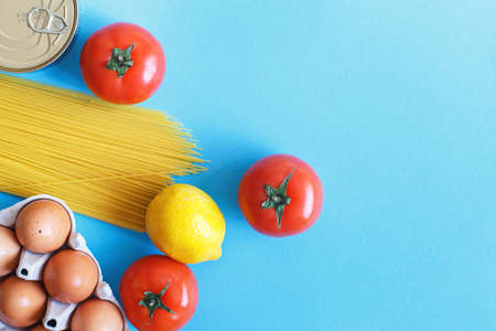 Different healthy food products on a blue background. Top view. fruit, vegetable, eggs and grocery online shop.your textの写真素材