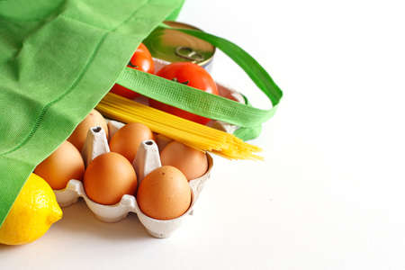 Full green bag of healthy food on a white background. Top view. fruit, vegetable, eggs online shop. your text. food deliveryの写真素材