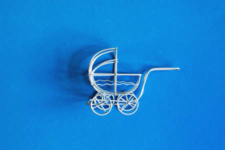 vintage toy baby stroller on blue background. toy carriageの写真素材
