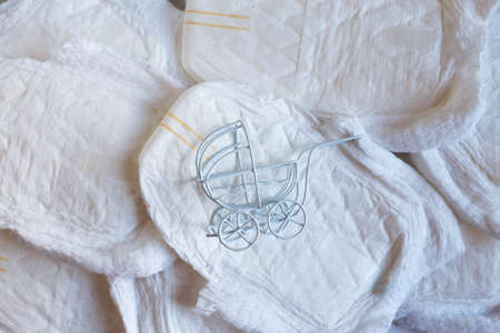 Baby diapers with toy carriage on a white backgroundの写真素材