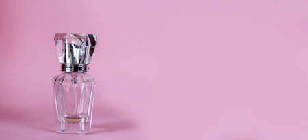 Perfume bottle used almost empty on a pink background. banner