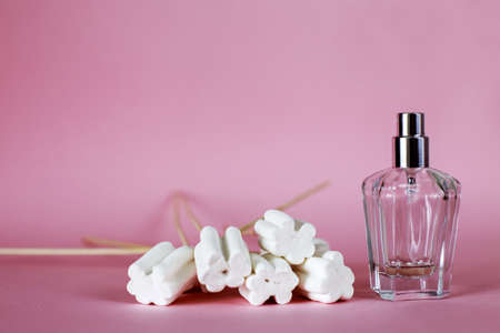 Sweet perfume bottle used almost empty on a pink background. long shadows. copy spaceの写真素材