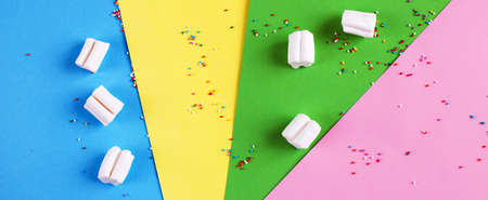 Colored marshmallow composition on a colorful background. Flat lay, holiday concept. banner