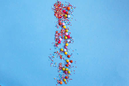 Sugar baking colorful sprinkles in shape of circle isolated on a blue background. Holiday concept....
