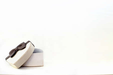 gift box in the form of a heart with gray bow on a white background. place for your textの写真素材