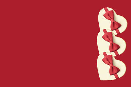 gift boxes in the form of a heart with red bow on a red background. place for your textの写真素材