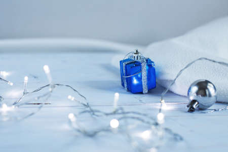 christmas garland and with present box sits on light blue wooden backgroundの写真素材