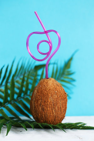 A coconut with straw on a blue background. Summer and trave concept. copy spaceの写真素材