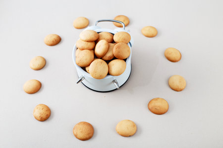 a sweet cookie in form of an alarm clock, time for breakfast or dessert concept. top view. mini...