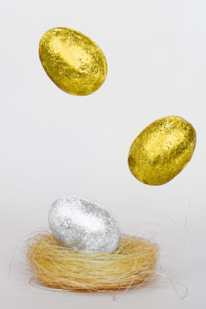 Illuminating Gold and silver Easter eggs levitation to the nest on a Ultimate Gray background. Easter concept. Trendy colors of the 2021 yearの写真素材