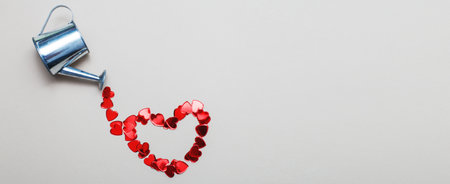 silver watering can flowers pouring hearts on light beige background. banner. Valentines background, love, date conceptの写真素材