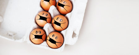 chicken eggs with drawn medical mask on egg carton on a white background. Easter eggs holidays...