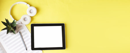 Top view open music book, headphones and a pen on a yellow background. mock up for a music lessons. bannerの写真素材