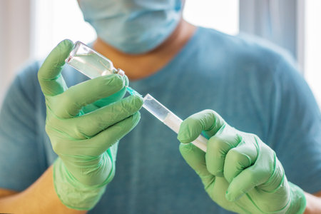 Hands of the doctor filling a syringe. Man hands in blue gloves holding vaccine. medicine, vaccination and drug concept. medicine vial dose injectionの写真素材