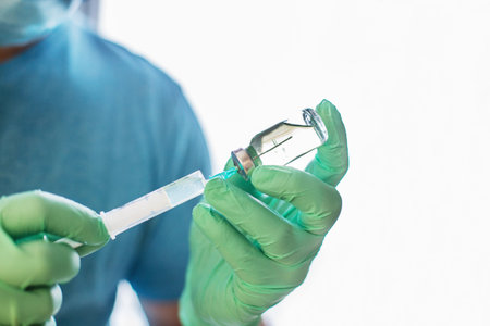 Hands of the doctor filling a syringe. Man hands in blue gloves holding vaccine. medicine, vaccination and drug concept. medicine vial dose injectionの写真素材