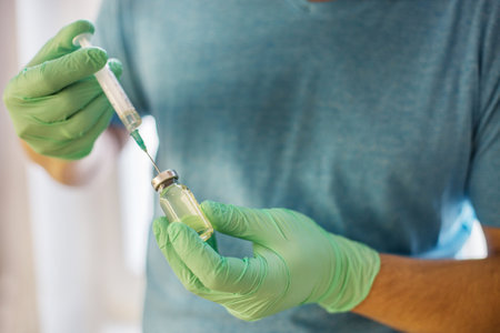 Hands of the doctor filling a syringe. Man hands in blue gloves holding vaccine. medicine, vaccination and drug concept. medicine vial dose injectionの写真素材