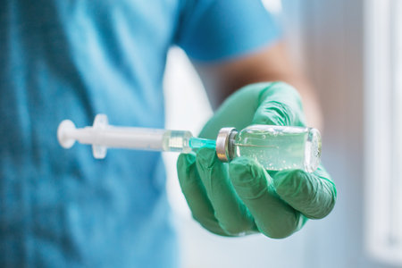 Hands of the doctor filling a syringe. Man hands in blue gloves holding vaccine. medicine, vaccination and drug concept. medicine vial dose injectionの写真素材