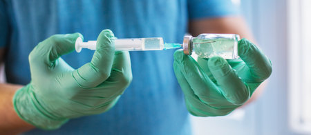 Hands of the doctor filling a syringe. Man hands in blue gloves holding vaccine. medicine, vaccination and drug concept. medicine vial dose injectionの写真素材
