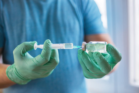 Hands of the doctor filling a syringe. Man hands in blue gloves holding vaccine. medicine, vaccination and drug concept. medicine vial dose injectionの写真素材