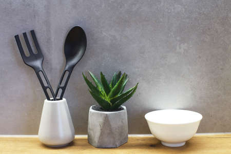 Different kitchen tools for cooking on gray concrete wall. Kitchenware with plastic materialの写真素材