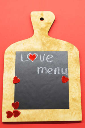 Cooking with love concept. cutting board with hearts and and the word MENU on red backgroundの写真素材