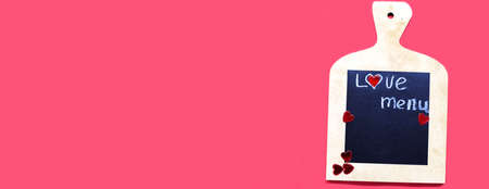 Cooking with love concept. cutting board with hearts and and the word MENU on red background. banner