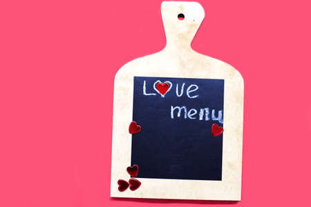 Cooking with love concept. cutting board with hearts and and the word MENU on red backgroundの写真素材