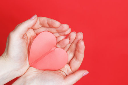 female hands hold a red heart on the palms isolated on a red background. Love, Wedding, Valentines day, 8 March concept. Copy space. your textの写真素材