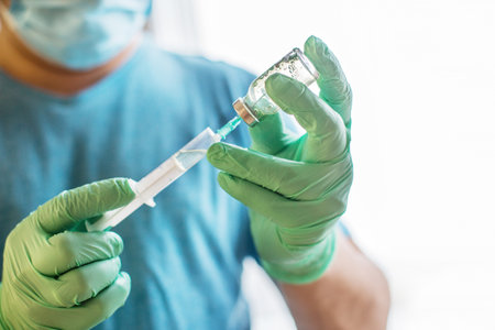 Hands of the doctor filling a syringe. Man hands in blue gloves holding vaccine. medicine, vaccination and drug concept. medicine vial dose injectionの写真素材