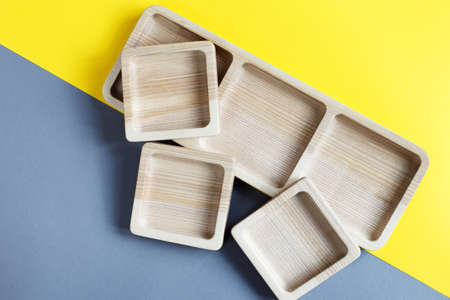 wood empty plates for snack on the color gray and yellow backgroundの写真素材
