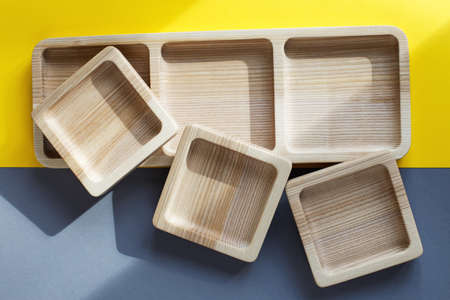 wood empty plates for snack on the color gray and yellow backgroundの写真素材