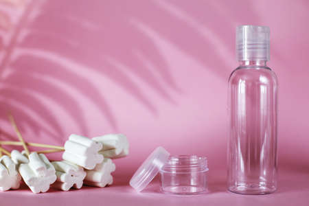 spa cosmetic products with sweets, transparent tube, branding mockup on a pink background. Plastic bottle for detergent cleaning agent. hard shadows. copy spaceの写真素材