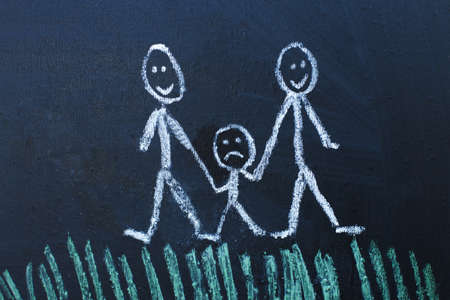 drawing happy homosexual parents with unhappy child in the family on a chalk board.の写真素材