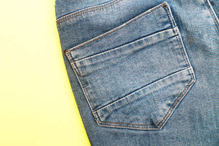 Back pockets of blue jeans on a yellow backgroundの写真素材