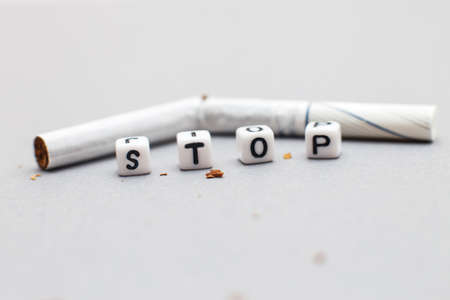 broken cigarette with the word stop on a gray background close. stop smoking conceptの写真素材