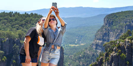 Tazi Canyon landscape in Manavgat Turkey. happy girls take selfies on the steep slope. valley and cliffの写真素材