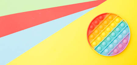a modern trendy silicone toy pop on a multicolored background. children's educational antistress toyの写真素材
