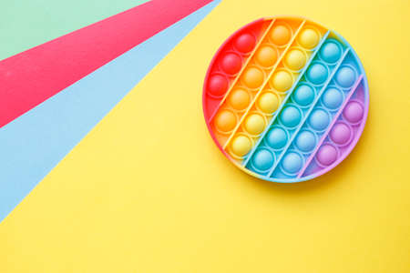 a modern trendy silicone toy pop on a multicolored background. children's educational antistress toy