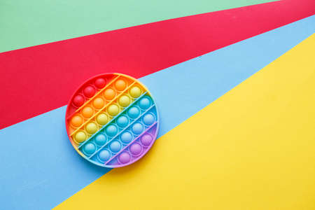 a modern trendy silicone toy pop on a multicolored background. children's educational antistress toyの写真素材