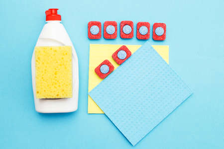 capsules for dishwashers, dishwashing detergents liquid, kitchen rag and sponges on a blue background. flat layの写真素材