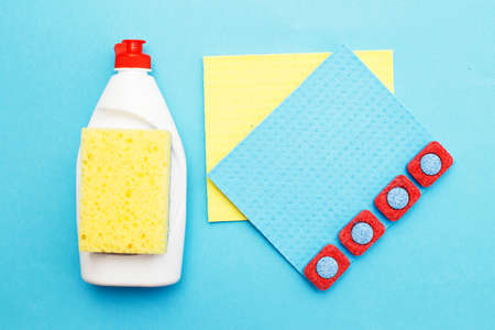 capsules for dishwashers, dishwashing detergents liquid, kitchen rag and sponges on a blue background. flat layの写真素材