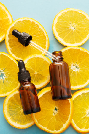 brown glass bottle with a pipette of face serum with vitamin C. Essential oil and orange slices. Health and beauty concept. Organic Natural Cosmetics.の写真素材