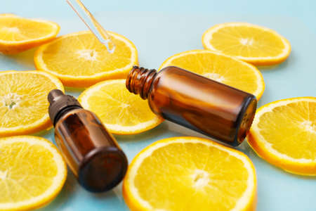brown glass bottle with a pipette of face serum with vitamin C. Essential oil and orange slices. Health and beauty concept. Organic Natural Cosmetics.の写真素材
