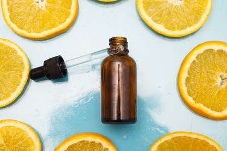 brown glass bottle with a pipette of face serum with vitamin C. Essential oil and orange slices. Health and beauty concept. Organic Natural Cosmetics.の写真素材