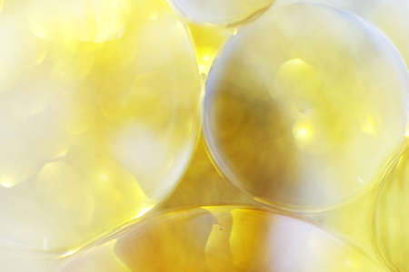 Gold Oil bubbles close up. a circles of water macro. abstract shiny light yellow backgroundの写真素材