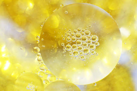 Gold Oil bubbles close up. a circles of water macro. abstract shiny light yellow backgroundの写真素材