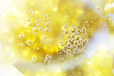 Gold Oil bubbles close up. a circles of water macro. abstract shiny light yellow backgroundの写真素材