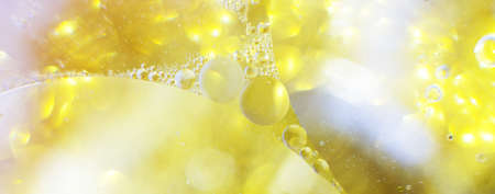 Gold Oil bubbles close up. a circles of water macro. abstract shiny light yellow background. bannerの写真素材
